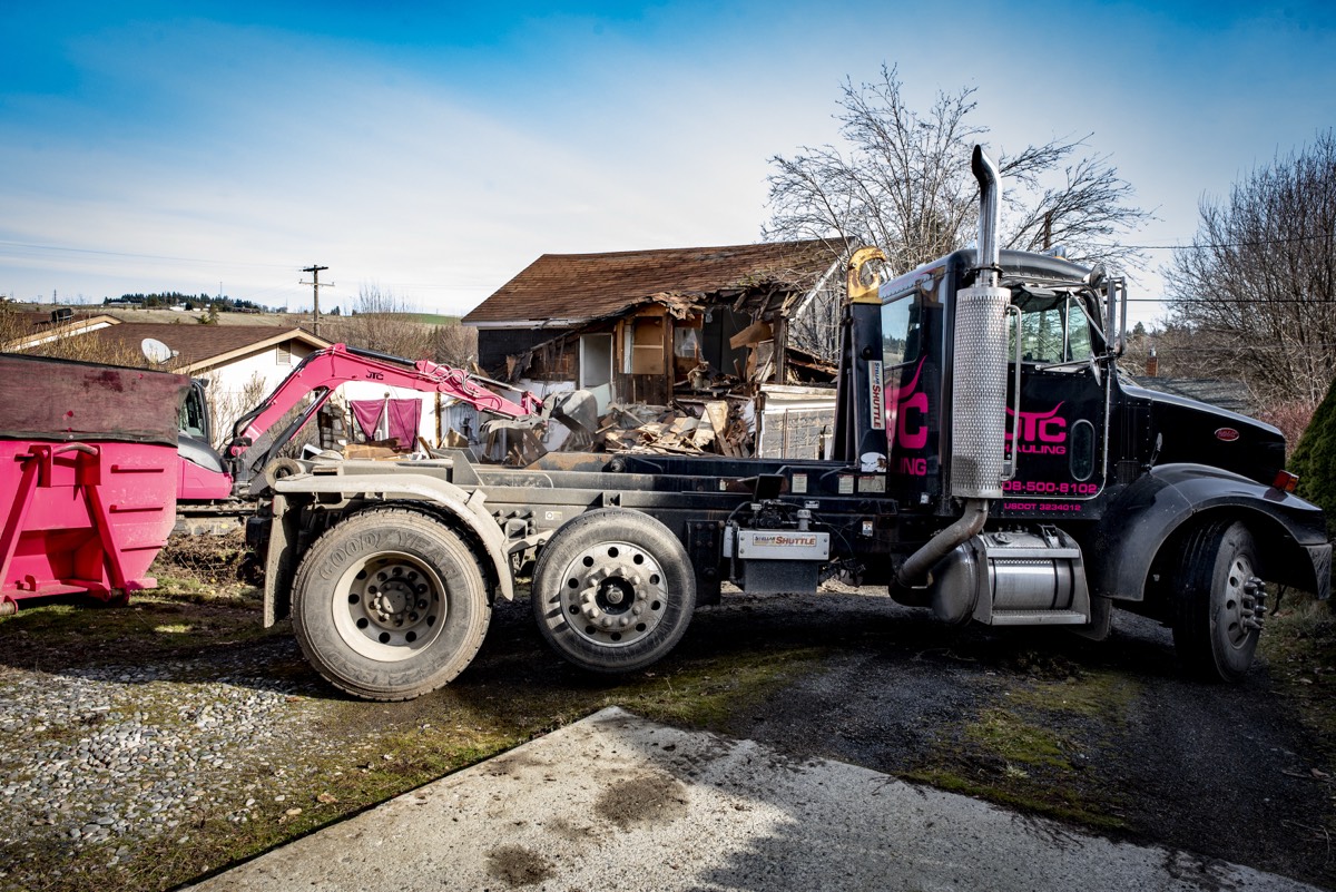 JTC truck and pink dumpster staged at a demolition site